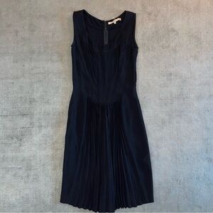 Black pleated mini dress with a touch of whimsy, featuring a fitted silhouette